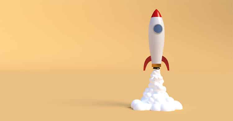 A 3D-style cartoon rocket with red fins and a rounded top lifts off, leaving behind a cloud of white smoke against a solid beige background. The image symbolizes launching a new project, startup, or idea with energy and momentum.