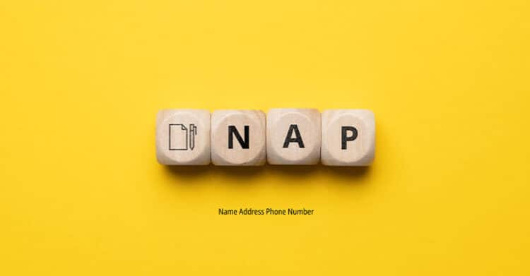 Wooden blocks on a bright yellow background spell out "NAP" with a small icon and the text "Name Address Phone Number" written below. The image refers to the local SEO concept of NAP consistency, which is crucial for accurate business listings across the web.