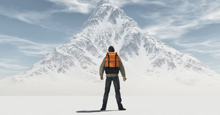 A lone hiker with an orange backpack stands facing a towering, snow-covered mountain under a partly cloudy sky. The image conveys themes of challenge, ambition, and determination, symbolizing the journey toward achieving a difficult goal.