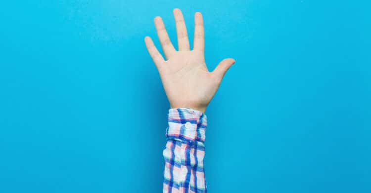 A single raised hand with an open palm reaches up from the bottom of the image against a bright blue background. The simple gesture suggests volunteering, asking a question, or signaling for attention.