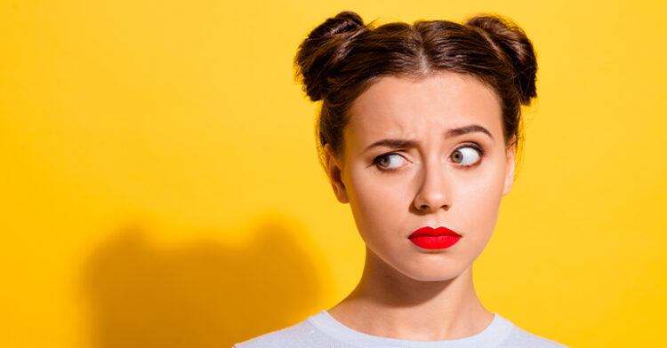 A young woman with a concerned expression, looking sideways, against a bright yellow background.
