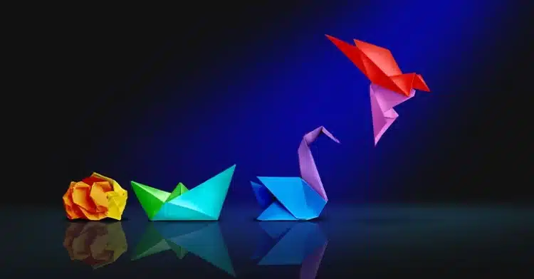 How to Develop a Personal Brand that Resonates 5 A collection of colorful origami figures, including a yellow rose, a green and blue boat, a blue and purple swan, and a red and purple bird in flight, set against a dark background with dramatic lighting.