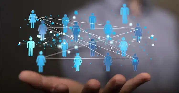 Person holding a digital network of connected human icons, representing communication, audience engagement, or social networking.