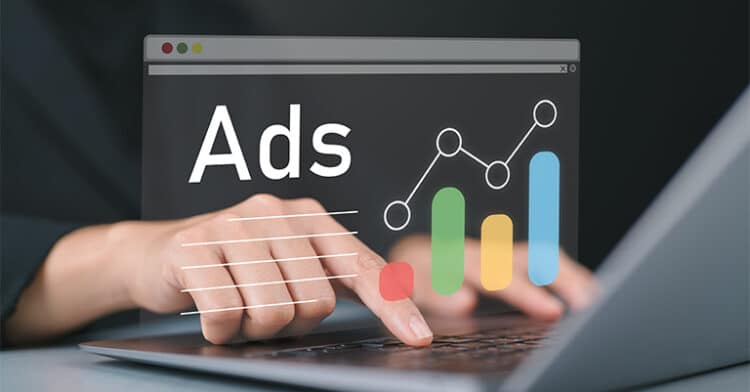 Hands typing on a laptop with digital ads and colorful performance graphs projected above the keyboard, symbolizing online advertising growth.
