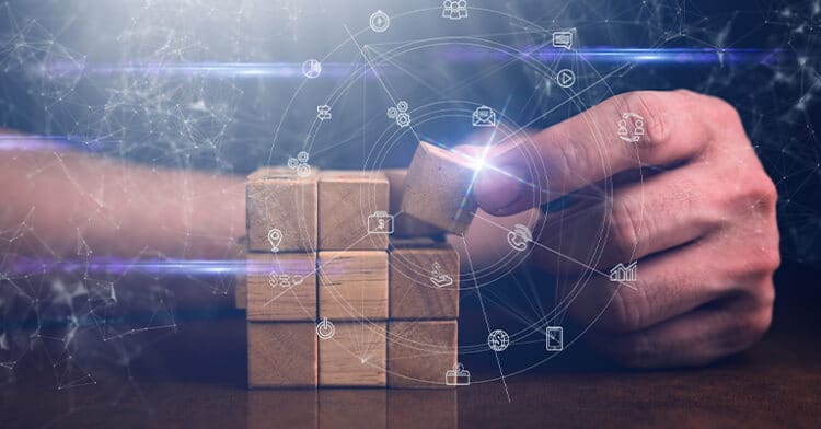 Hand arranging wooden blocks with overlaid digital icons representing search, communication, and analytics, symbolizing digital marketing strategy design.