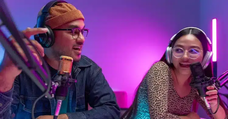 How to Use Social Media Influencers to Improve Your Marketing 3 Two young podcasters recording together in a vibrant, neon-lit studio with headphones and professional microphones.