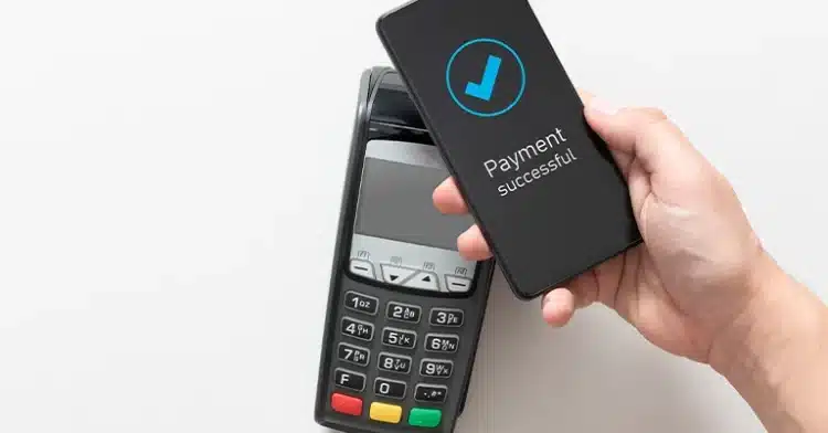 How to Use Social Media Influencers to Improve Your Marketing 8 Close-up of a smartphone displaying “Payment Successful” while making a contactless payment via card reader.