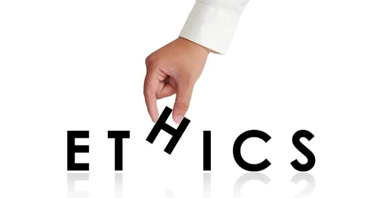Hand rearranging the letter "H" in the word "ETHICS," symbolizing ethical decision-making and manipulation.