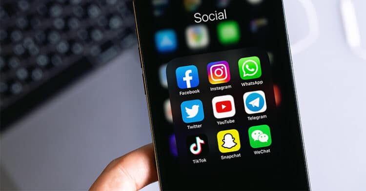 Close-up of a smartphone screen showing popular social media app icons in a "Social" folder.