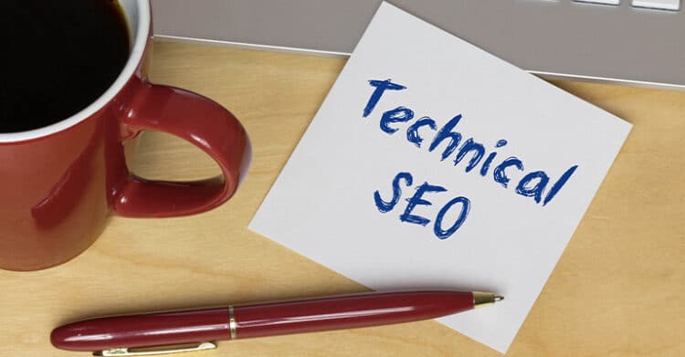 A desk scene shows a red coffee mug, a pen, and a sticky note that reads Technical SEO in blue handwriting. The image represents technical SEO work, planning, or website optimization tasks in a casual workspace setting.