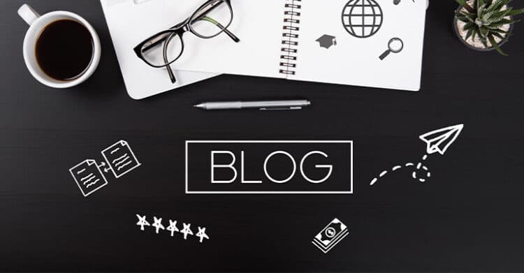 The Benefits of Blogging: Build Traffic, 3 A flat lay of a black desk with a coffee cup, eyeglasses, a pen, and a spiral notebook showing icons like a globe and magnifying glass. The word BLOG appears in the center with doodles of documents, star ratings, a money icon, and a paper airplane.