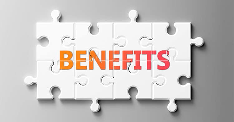 The Benefits of Blogging: Build Traffic, 11 White jigsaw puzzle pieces fit together on a gray background with the word BENEFITS in bold orange letters across the center. The connected pieces suggest multiple advantages coming together as part of one solution.