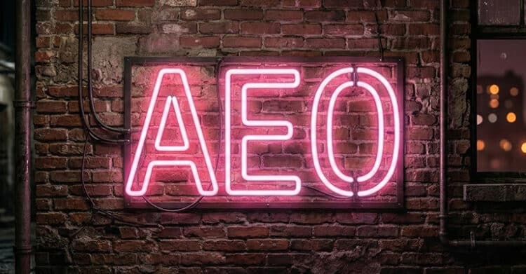 Pink neon sign mounted on a brick wall spells "AEO" with exposed wiring and a warm urban glow. The bold storefront style visual supports content optimization by emphasizing answer engine optimization in a modern marketing context.