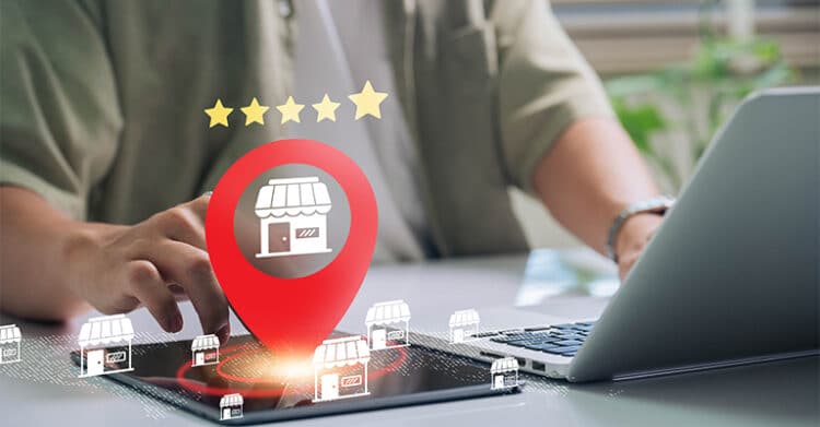 What Is Local SEO? A Complete Guide for Small Businesses 13 Person works on a laptop while a large red map pin with a storefront icon glows over a digital map and small shop icons. Five stars above the pin suggest ratings and visibility, showing local SEO helping businesses stand out in nearby search results.