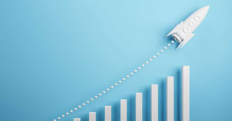 White 3D rocket launching upward across a light blue background above a rising bar chart. Dotted exhaust trail and increasing columns symbolize rapid growth or a performance boost.