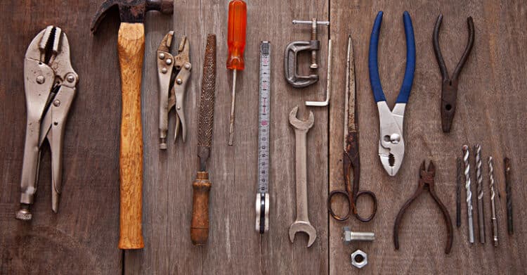 How to Write Blog Titles that Earn Clicks (A Complete Guide) 8 Assortment of hand tools lined up on a wooden surface including pliers, a hammer, screwdrivers, wrenches, scissors, and drill bits. This visual suits a post about Blog Titles by suggesting the right tools and techniques for building stronger headlines.