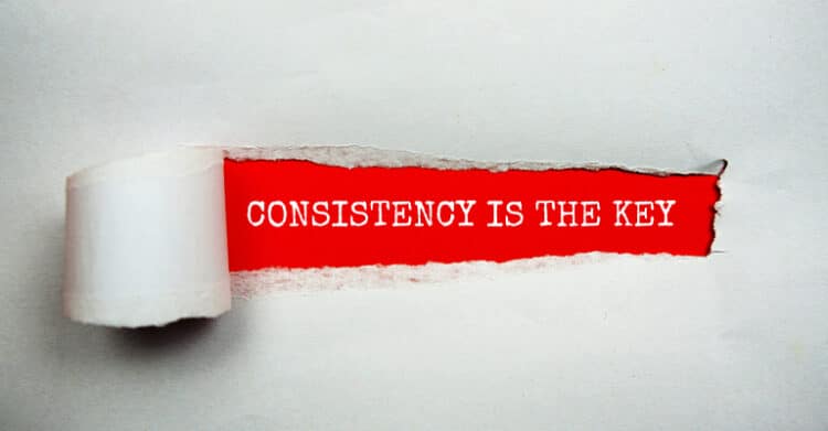 Torn white paper reveals a bold red strip with the words "CONSISTENCY IS THE KEY." This graphic supports advice to increase social media engagement by emphasizing that steady posting and repeated effort matter over time.