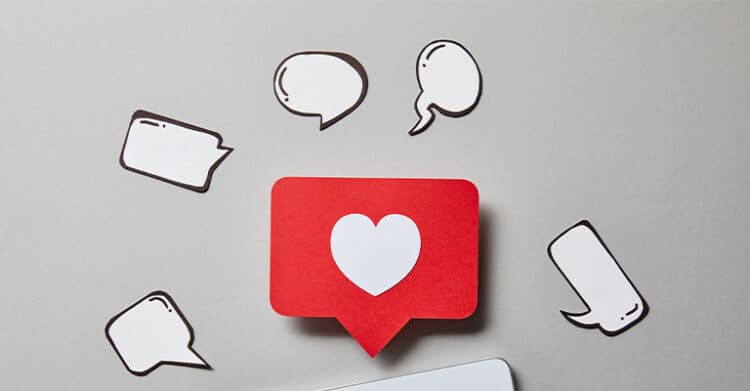 Red social media notification icon with a white heart in the center surrounded by empty speech bubbles representing engagement and communication. Visual metaphor for social media rules highlighting interaction guidelines and user responses online.