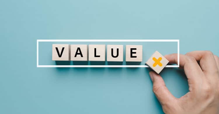 Wooden letter blocks spelling VALUE inside a white outlined box on a blue background while a hand places a block marked with a yellow X at the end. Visual for social media rules emphasizing the value of content and the importance of rejecting what does not add value.vvvvv